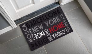 zerbino con fondo grigio in velluto e stampa nomi città nel mondo e "Home" (colori: grigio, nero, bianco, rosso)