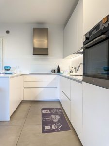 Tappeto in poliestere con stampa digitale, fondo beige e stampa di vasetti di fiori marroni. Rifinito con bordino tono su tono.