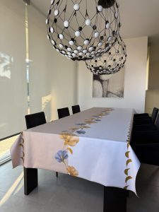 tovaglia con doppio colore a metà bianco e beige e al centro stampa di fiori oro e blu con effetto glitter