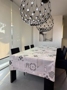 Tovaglia con piastrelle effetto ceramiche e utensili da cucina sui toni neutri del beige e grigio