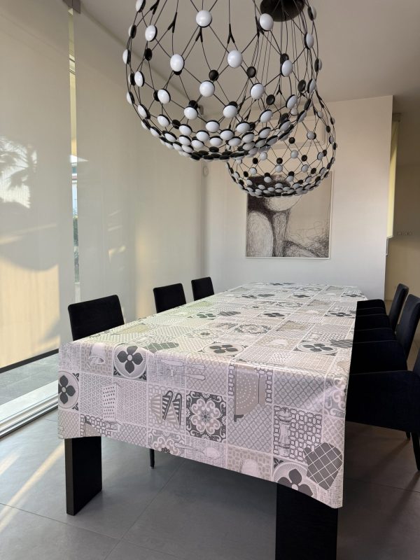 Tovaglia con piastrelle effetto ceramiche e utensili da cucina sui toni neutri del beige e grigio
