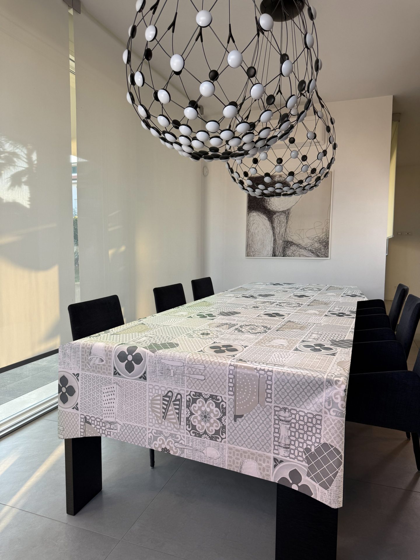 Tovaglia con piastrelle effetto ceramiche e utensili da cucina sui toni neutri del beige e grigio
