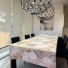 tovaglia con fondo beige con stampa di fiori bianchi e palme oro, beige e grigie