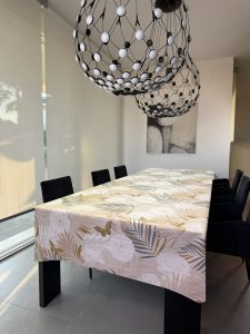 tovaglia con fondo beige con stampa di fiori bianchi e palme oro, beige e grigie